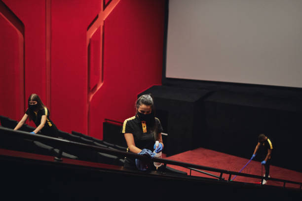 emale employees disinfecting movie theater