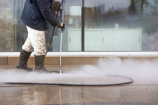 Worker delivering high pressure cleaning services.